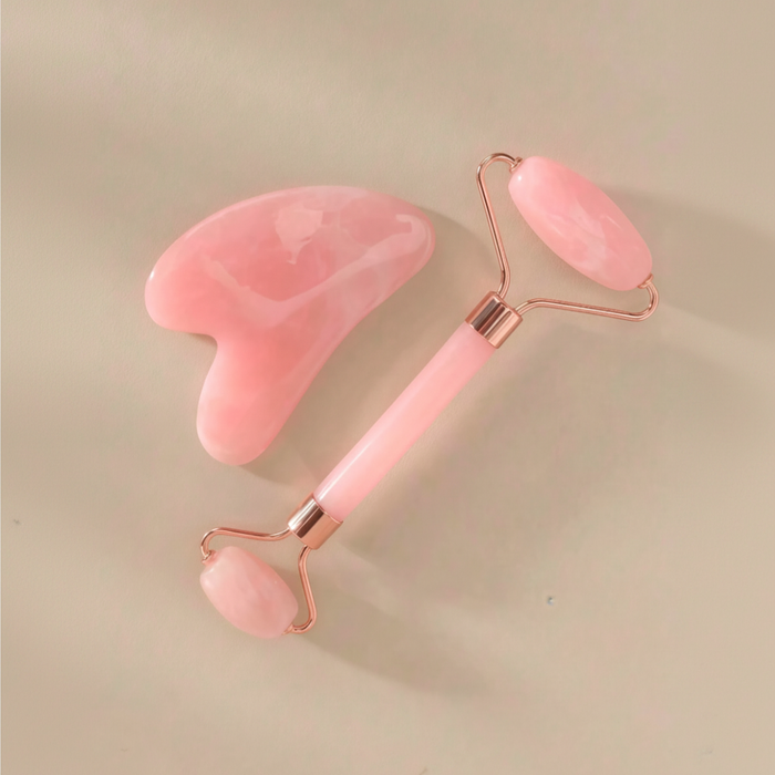 Square flat-lay product photo of the pink facial roller and heart-shaped gua sha